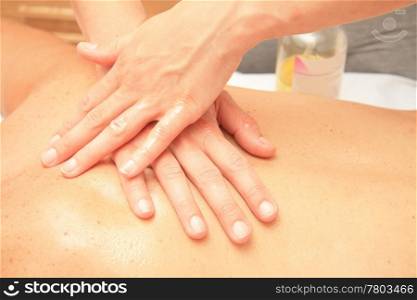 A female masseur giving massage, detail of hands on back