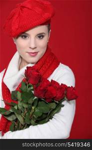A female model holding a bunch of red roses.