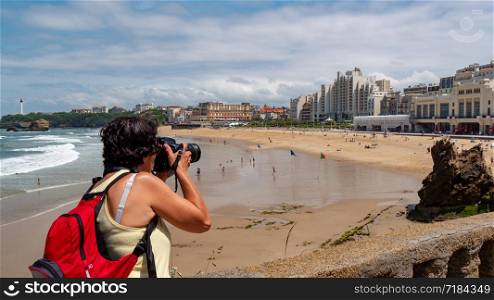 a female photographer taking a photograph of the Biarritz city