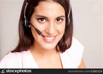 A female receptionist smiling at the viewer talking on the phone