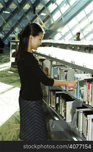 A female student checking out books at the library