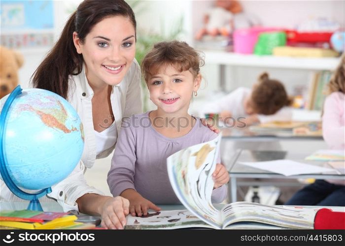 a female teacher and a little girl in a classroom