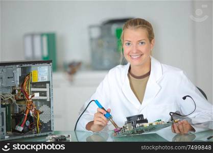 a female worker soldering the computer parts