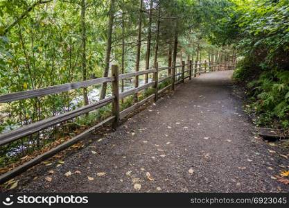 A fence and path follow the Tumwater River in Washington State.