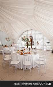 A festive wedding tent in anticipation of the ceremony.. The wedding hall is in a huge tent 3782.