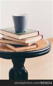 A few books with cup of coffee on chair