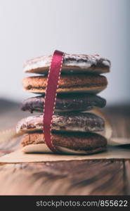 A few gingerbread cookies wrapped in red ribbon Happy Christmas. Plain background. Portrait orientation