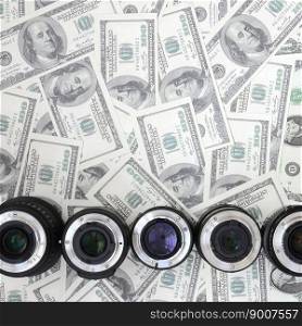 A few photographic lenses lies on the background of a lot of dollar bills. Space for text