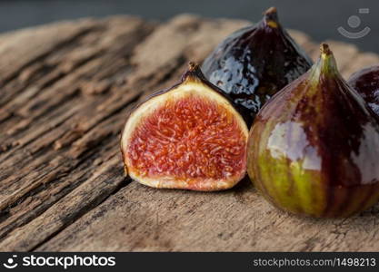A few ripe figs on an old wooden background. Seasonal fruits.. A few ripe figs on an old wooden background.