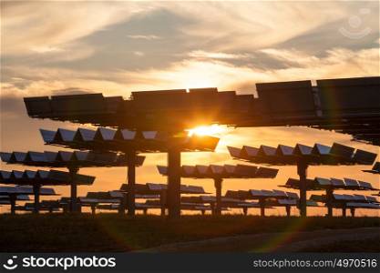 A field of photovoltaic solar panels providing alternative green energy at sunrise or sunset