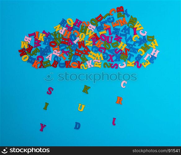 a figure of a cloud of multi-colored wooden letters on a blue background