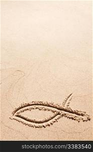 A fish symbol in drawn in the sand