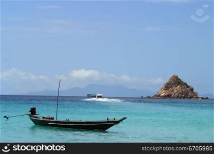 A Fishing boat mores off the coast on Koh Tao, tranquil, tranquility, tropical, paradise, pristine, tropical, heaven, delight, joy, haven, retreat, sanctuary, oasis, Thailand.