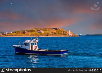 A Fishing Boat Past a Small Lighthouse and Shed in Halifax, Nova Scotia, Canada