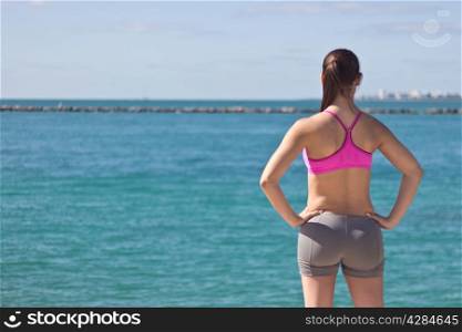 A fit woman looking at the ocean
