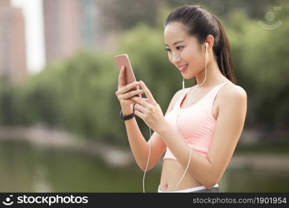 A fitness woman listening to music on her phone