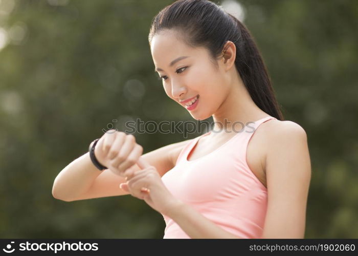 A fitness woman looking at her exercise bracelet