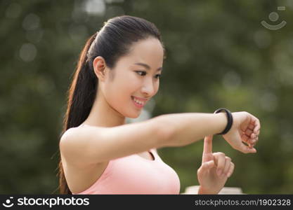 A fitness woman looking at her exercise bracelet