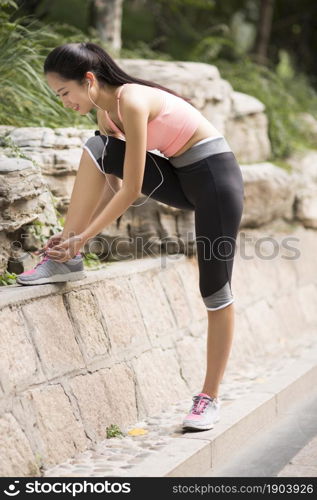 A fitness young woman tying her shoes