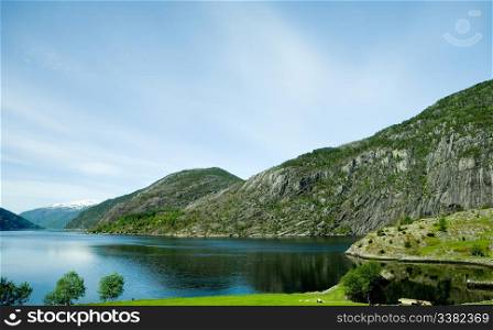 A fjord and rural norway with a blue sky