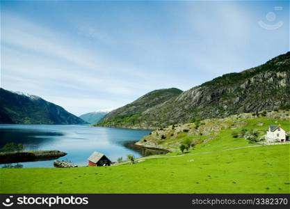 A fjord and rural norway with a blue sky