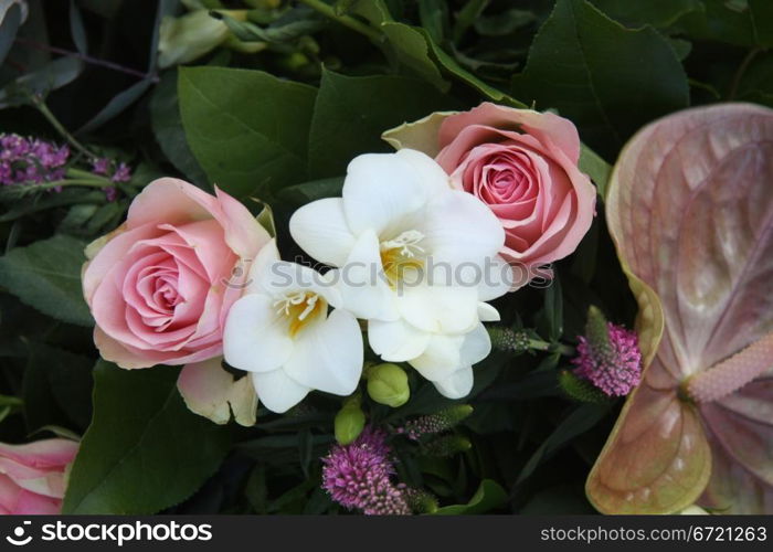 A floral arrangement made of soft pink roses and white freesias