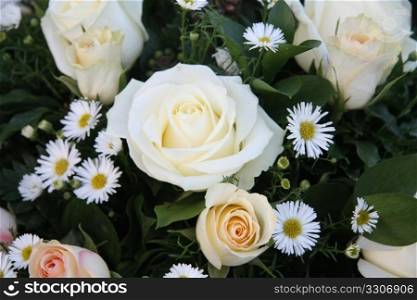 A flower arrangement with soft pink and white roses