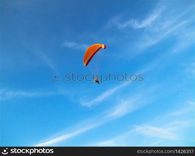 A flying paramotor on a vibrant sky with cloud. Extreme sport.