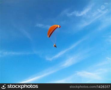 A flying paramotor on a vibrant sky with cloud. Extreme sport.