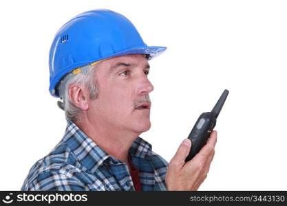 A foreman talking on a walkie-talkie.
