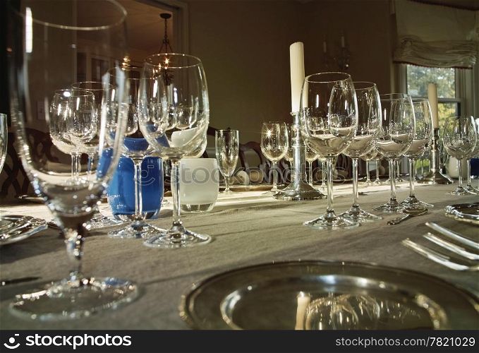 A formal dinner table set with mulitiple wine glasses for a wine tasting party.