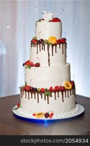 A four-story wedding cake.. A huge cake decorated with fruits and berries for the wedding 2773.