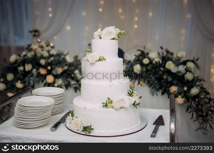 A four-tiered cake decorated with green leaves.. A snow-white cake with four tiers 3849.