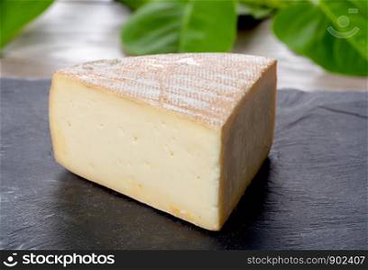 a french Morbier cheese on a slate plate