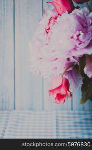 A fresh bouquet of pink peonies and tulips on a blue wooden background. Peonies and tulips