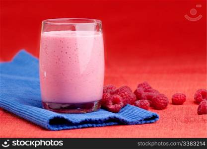 A fresh fruit raspberry smoothie isolated on red and blue