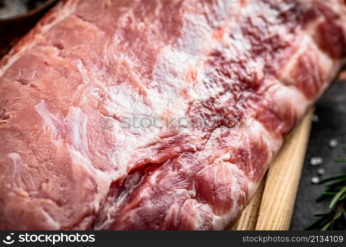 A fresh piece of raw pork on a cutting board. High quality photo. A fresh piece of raw pork on a cutting board.
