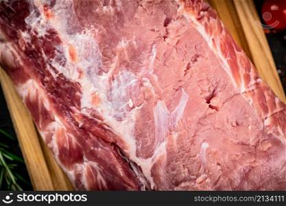 A fresh piece of raw pork on a cutting board. High quality photo. A fresh piece of raw pork on a cutting board.