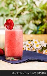 A fresh summer strawberry drink in an outdoor setting
