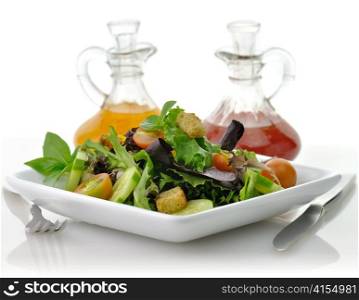 a fresh vegetable salad in a white dish with salad dressing