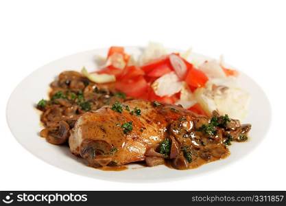 A fried chicken breast topped with mushrooms in a creamy sauce and served with a salad, isolated on white.