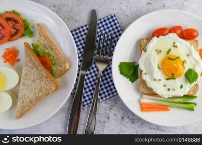 A fried egg laying on a toast, topped with pepper seeds with carrots and spring onions.