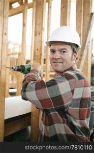 A friendly carpenter drilling on a construction site. Vertical view with room for text.