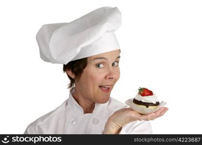 A friendly female chef holding a strawberry cheesecake tart. Isolated on white.