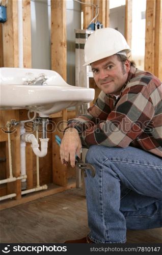 A friendly plumber installing bathroom fixtures on a construction site.