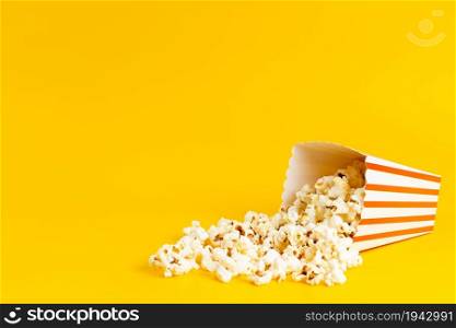 a front view popcorn inside package salted fresh isolated on the yellow background movie corn seed. a front view popcorn inside package