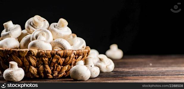 A full basket of mushrooms on the table. On a black background. High quality photo. A full basket of mushrooms on the table.