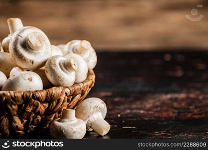 A full basket of mushrooms on the table. On a wooden background. High quality photo. A full basket of mushrooms on the table.