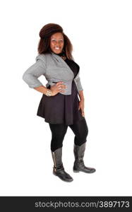 A full body picture of a young African American woman in a black dressand grey jacket and boots, standing isolated for white background.