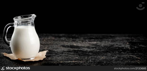 A full jug of fresh milk. On a black background. High quality photo. A full jug of fresh milk.